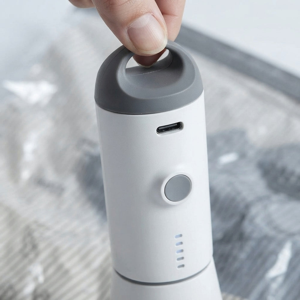 Close-up of Pack & Press™ portable vacuum pump showing USB-C charging port and power button